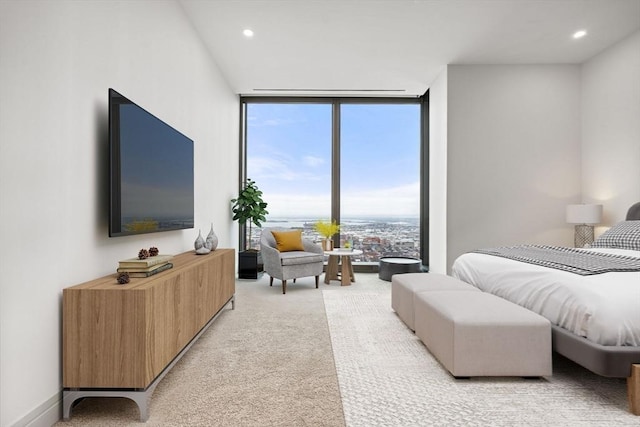 bedroom featuring a wall of windows and light carpet