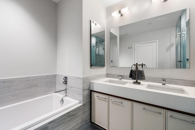 bathroom with vanity and a relaxing tiled tub