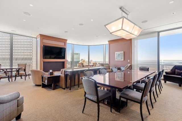 dining area featuring a wall of windows and light carpet