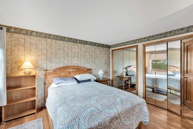 41 Kenwood Rd, Bourne, MA 02559 - bedroom featuring light wood-type flooring, two closets, and wallpapered walls