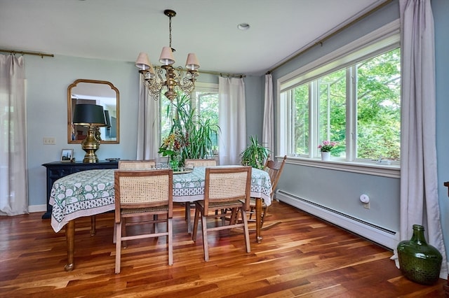 dining room with a notable chandelier, a baseboard heating unit, and hardwood / wood-style floors