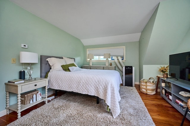 bedroom with vaulted ceiling and dark hardwood / wood-style floors