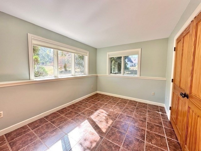 tiled empty room featuring a wealth of natural light