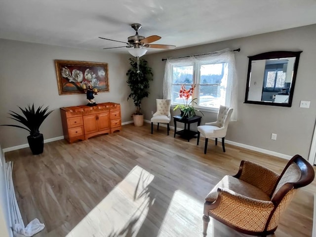 living area with light hardwood / wood-style floors and ceiling fan