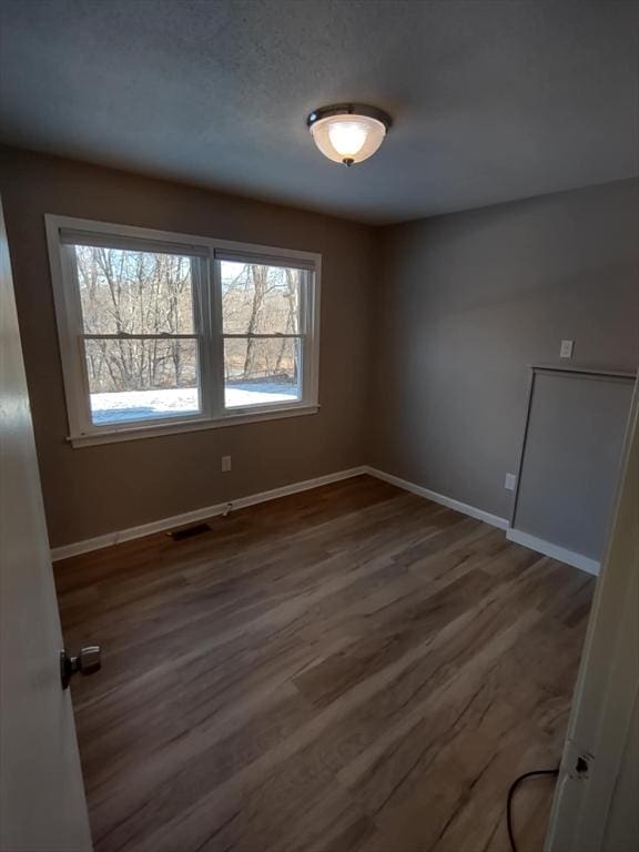 spare room featuring dark wood-type flooring