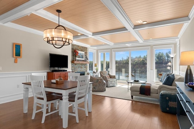 dining space featuring coffered ceiling, a notable chandelier, beam ceiling, and hardwood / wood-style floors