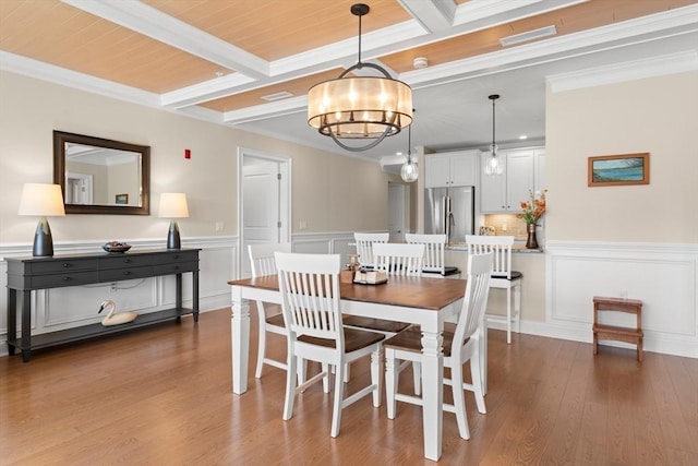 dining area with coffered ceiling, ornamental molding, a notable chandelier, and beamed ceiling