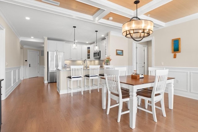 dining room featuring crown molding, recessed lighting, a notable chandelier, and a decorative wall