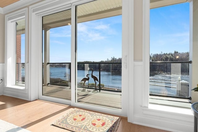 doorway to outside with wood finished floors and a water view
