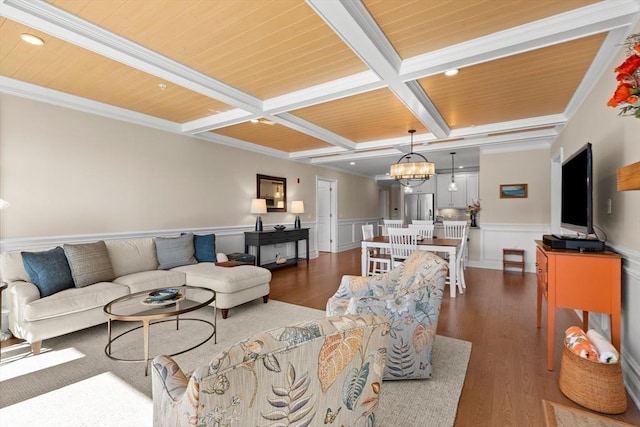 living room featuring a wainscoted wall, coffered ceiling, beam ceiling, dark wood finished floors, and a notable chandelier
