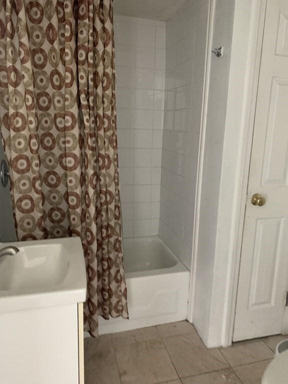 bathroom featuring tile patterned flooring, vanity, and shower / tub combo with curtain