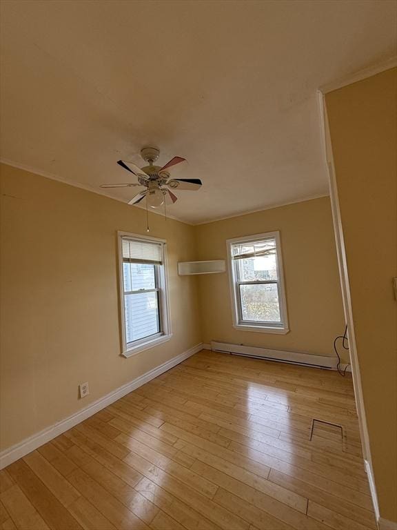 spare room featuring ceiling fan, light hardwood / wood-style flooring, and a baseboard radiator