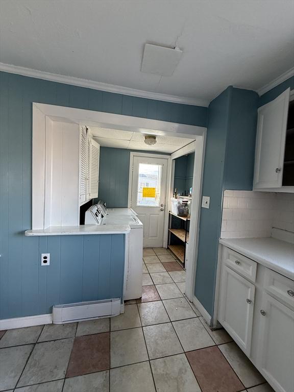 kitchen with white cabinetry, washing machine and dryer, crown molding, decorative backsplash, and light tile patterned flooring