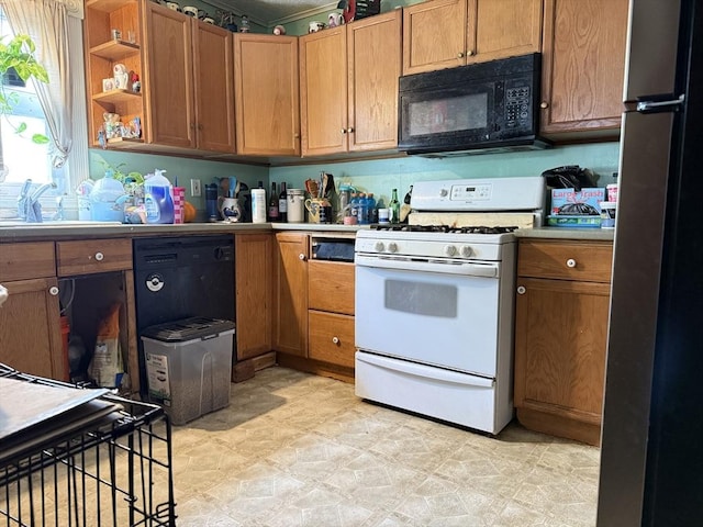 19 Davis St, Woburn, MA 01801 - kitchen featuring black microwave, white gas range, freestanding refrigerator, a sink, and light countertops