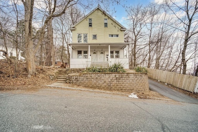 view of front facade featuring fence and a porch