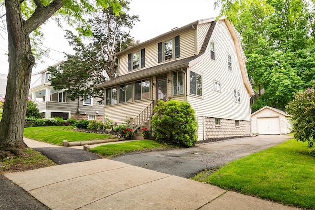 47 Ronald Rd, Arlington, MA 02474 - view of front of property with an outdoor structure, a front lawn, and a garage