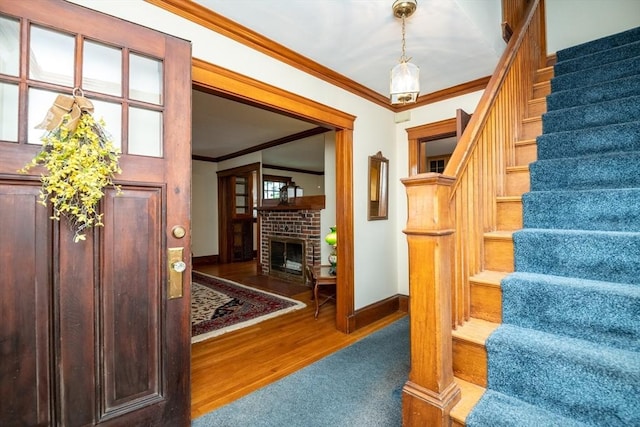 47 Ronald Rd, Arlington, MA 02474 - staircase featuring ornamental molding, baseboards, wood finished floors, and a fireplace