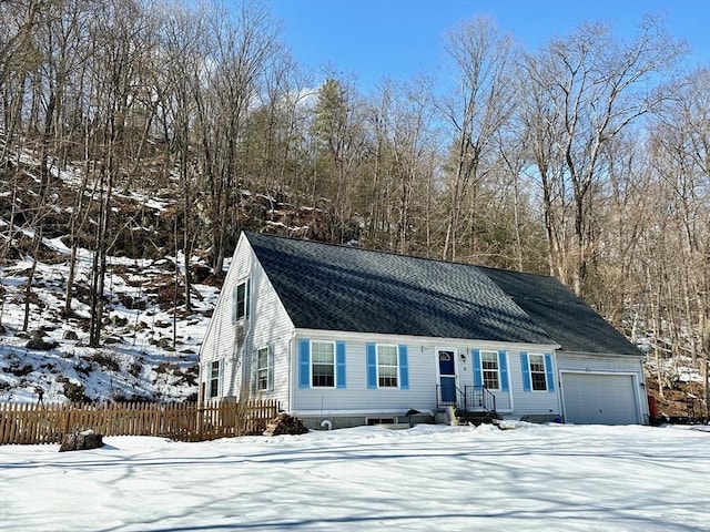 view of front of house with an attached garage, fence, and roof with shingles