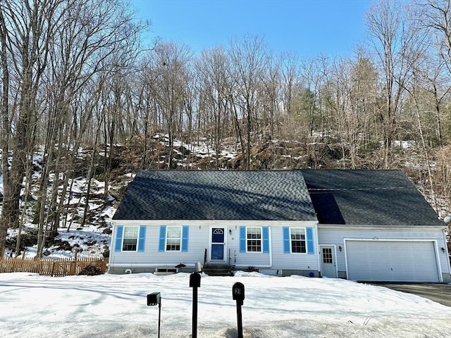 view of front of house with a shingled roof, entry steps, fence, and an attached garage