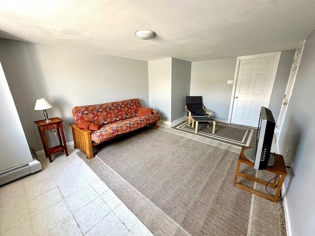 sitting room with a baseboard heating unit, baseboards, and tile patterned floors