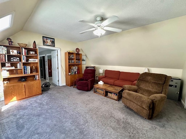 carpeted living room with a ceiling fan, vaulted ceiling, and a textured ceiling