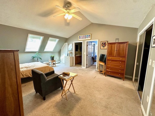 bedroom featuring vaulted ceiling with skylight, baseboards, light colored carpet, ceiling fan, and a textured ceiling