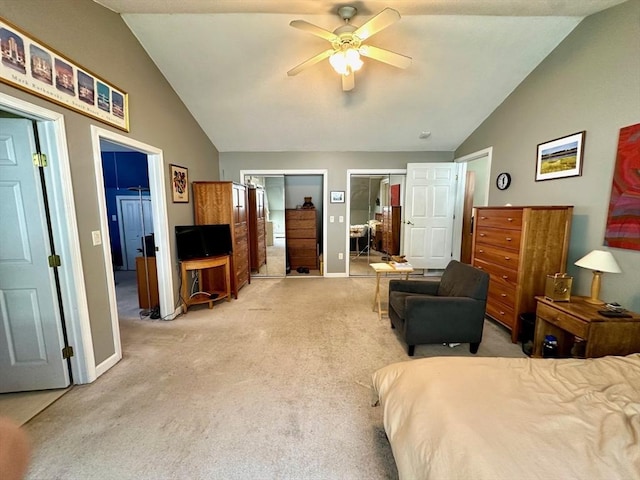 bedroom with light carpet, baseboards, a ceiling fan, vaulted ceiling, and multiple closets