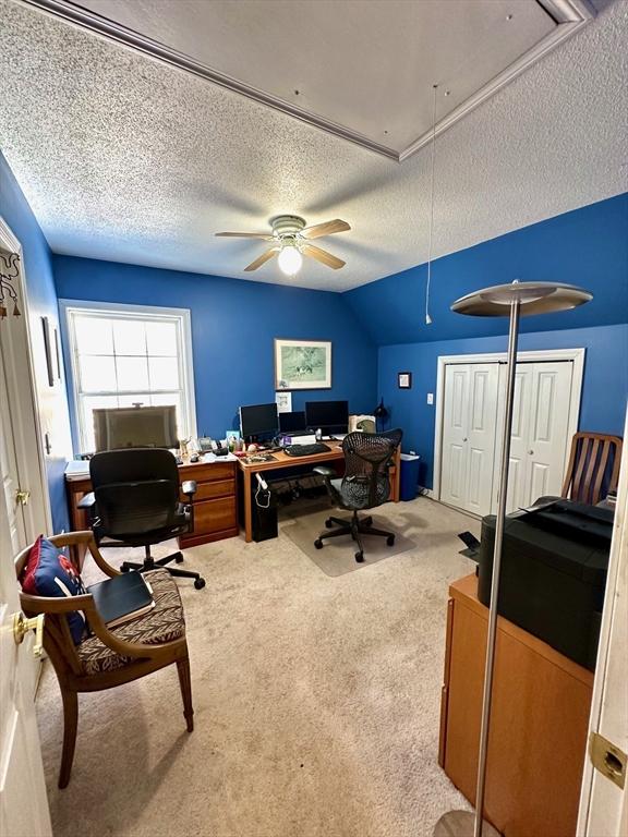 office area featuring a textured ceiling, attic access, and light colored carpet