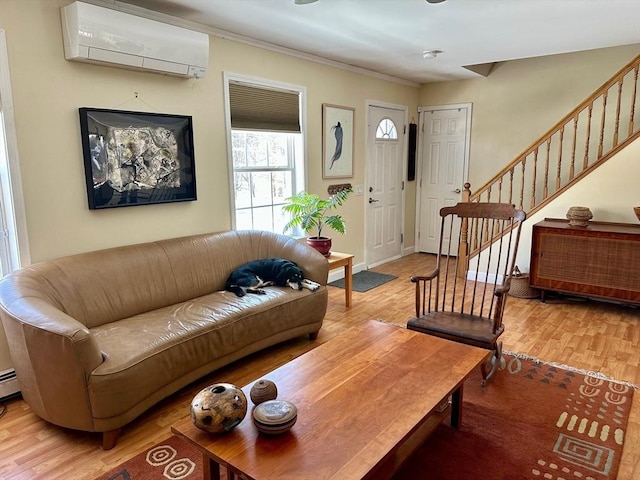 living room with stairs, ornamental molding, a wall mounted air conditioner, and light wood-style floors