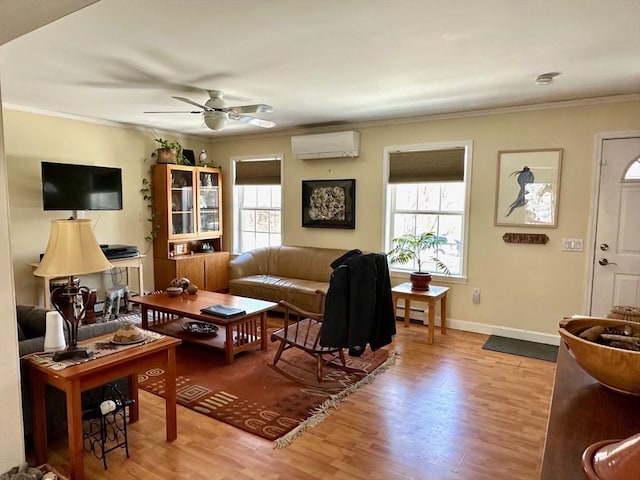 living room featuring baseboards, a ceiling fan, ornamental molding, wood finished floors, and an AC wall unit