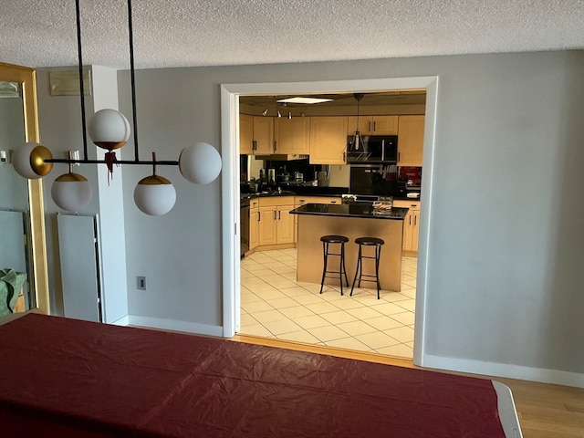 kitchen featuring light hardwood / wood-style flooring, a textured ceiling, a breakfast bar, and a center island