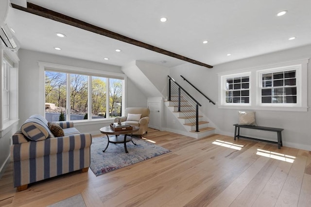 living area featuring stairway, baseboards, light wood-type flooring, and beam ceiling
