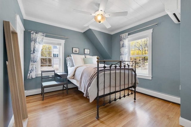 bedroom with baseboards, a baseboard radiator, and wood finished floors