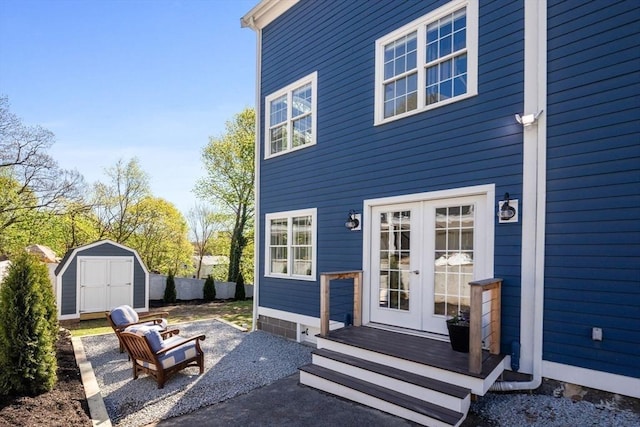 back of property with a patio, french doors, an outdoor structure, and a storage unit