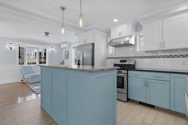 kitchen featuring a wall unit AC, a kitchen island, under cabinet range hood, stainless steel appliances, and light wood-style flooring