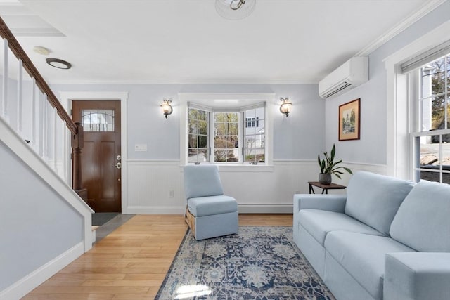 living room featuring wood finished floors, wainscoting, baseboard heating, and a wall mounted air conditioner