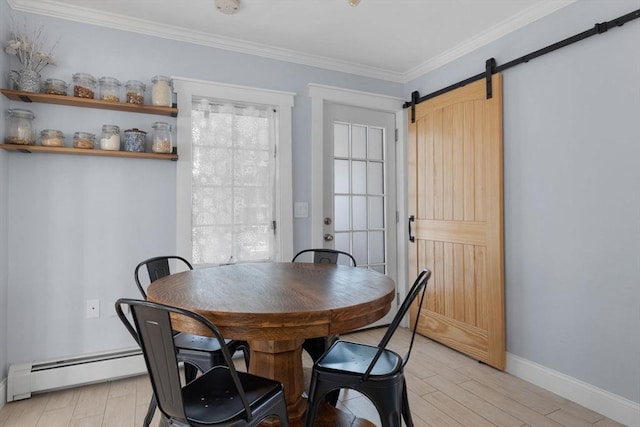 dining room featuring baseboards, ornamental molding, light wood finished floors, and a barn door