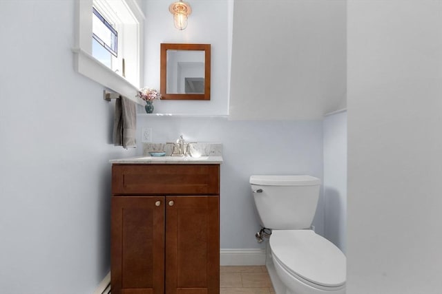 bathroom with toilet, baseboards, and vanity