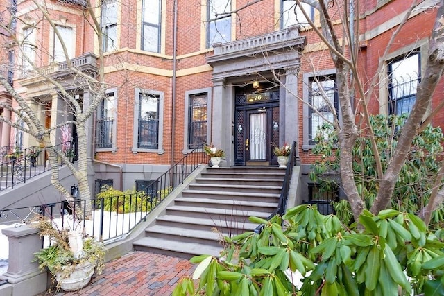 doorway to property featuring brick siding