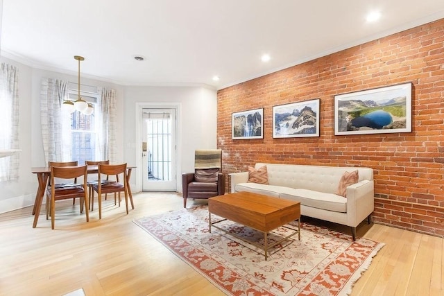 interior space with light wood-style floors, crown molding, and brick wall