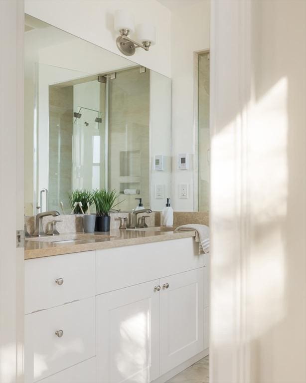 bathroom with a shower with shower door and vanity