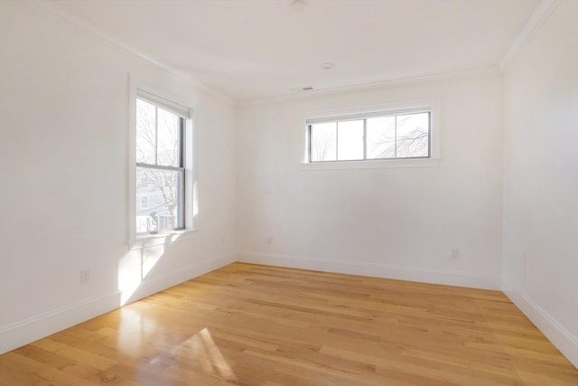 empty room featuring light hardwood / wood-style flooring and ornamental molding