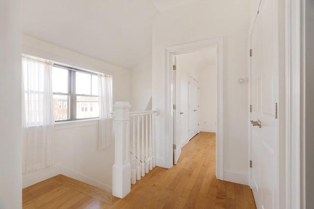 corridor featuring light hardwood / wood-style floors and lofted ceiling