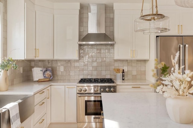 kitchen with white cabinets, backsplash, high end appliances, and wall chimney exhaust hood