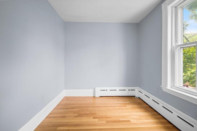spare room featuring plenty of natural light, light wood-style flooring, baseboards, and baseboard heating