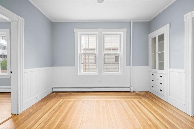 unfurnished room with a wainscoted wall, a baseboard radiator, wood finished floors, and crown molding