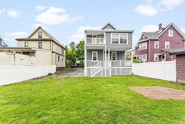 rear view of property with covered porch, a balcony, and stairs