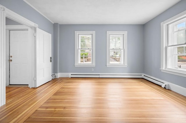 empty room featuring a baseboard heating unit and light wood-type flooring