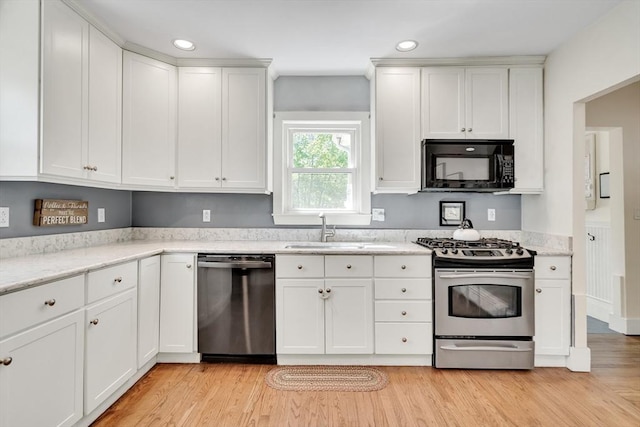 kitchen featuring a sink, recessed lighting, light wood-style flooring, white cabinetry, and appliances with stainless steel finishes
