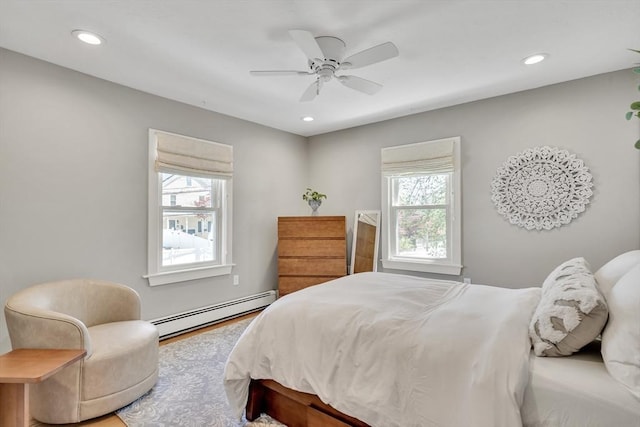 bedroom with a baseboard heating unit, recessed lighting, a ceiling fan, and wood finished floors